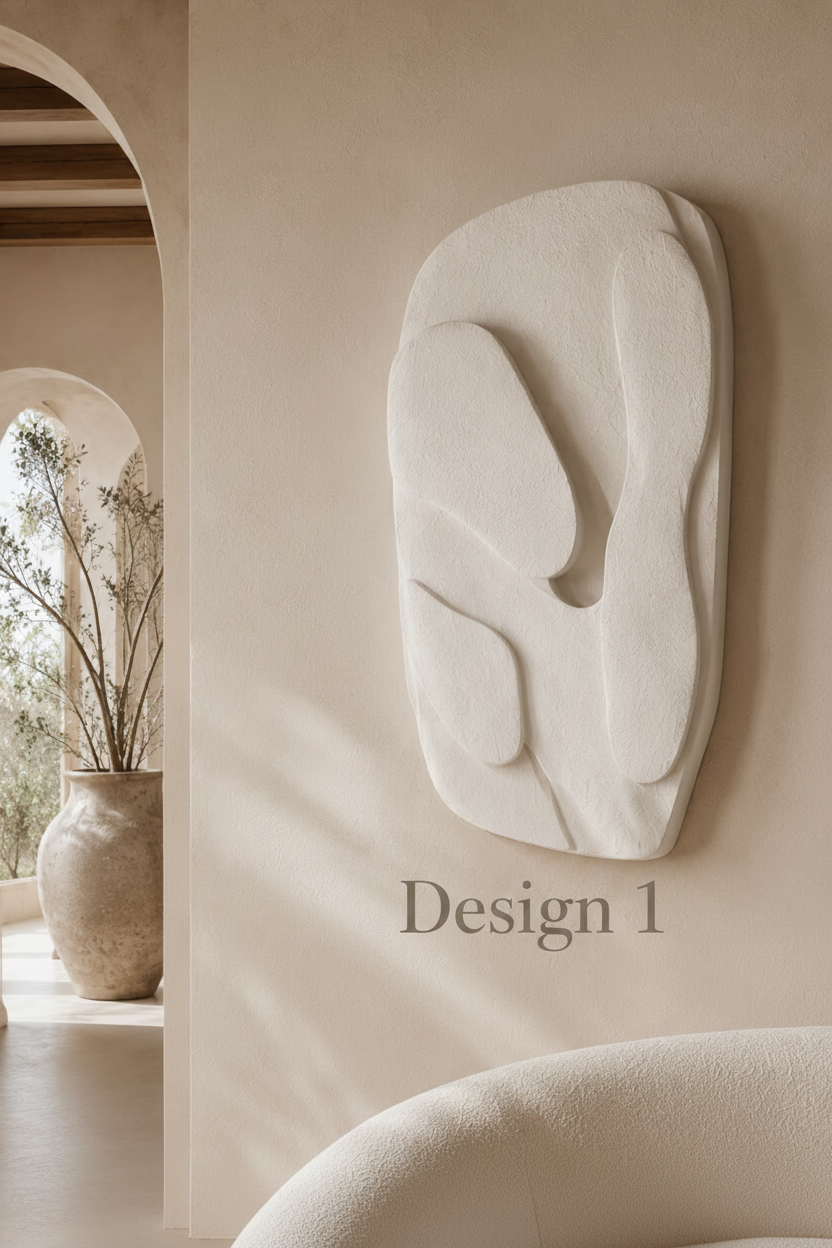 An abstract, organic-shaped white wall sculpture mounted on a warm beige plaster wall in a softly lit interior with arches and a vase in the background.