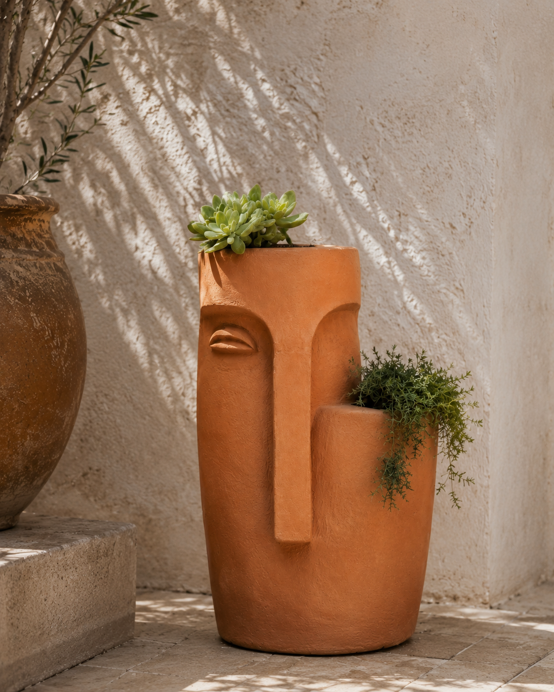Double Stacked Face Planter, a sculptural plaster planter with a stacked face motif in a matte stone-look finish