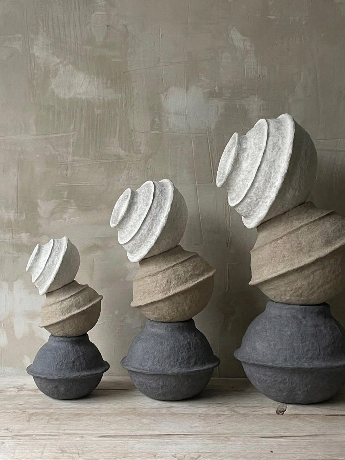 Three Plaster Column Totems in different heights shown side by side against a plaster wall